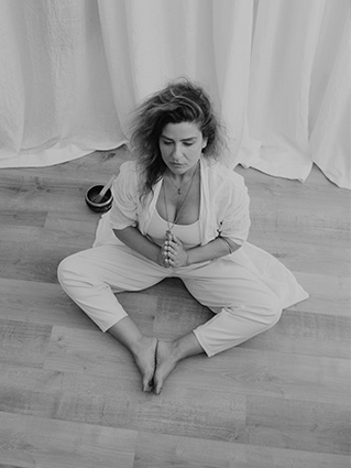 Instructora de yoga sentada en postura de meditación, enfocada y serena.